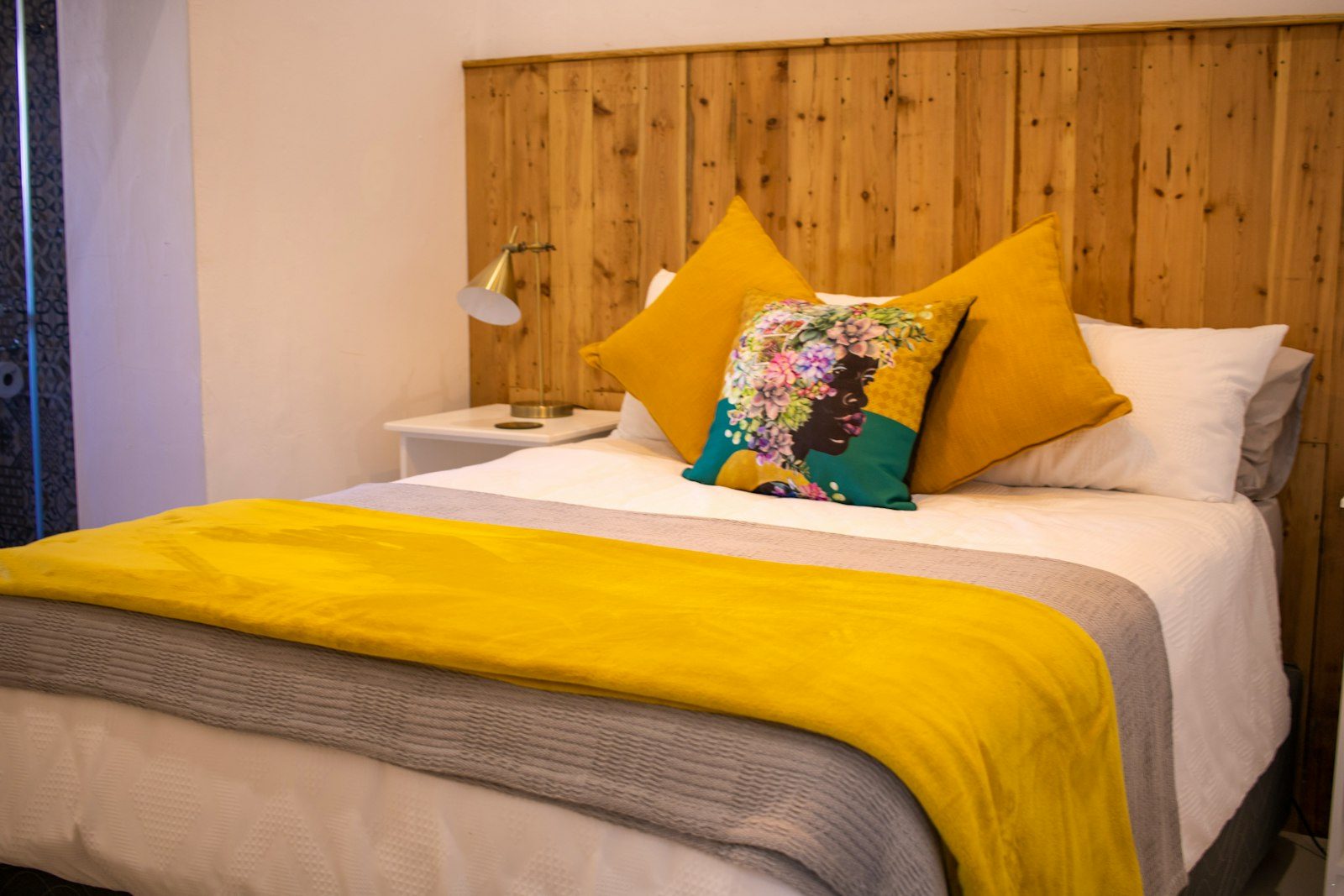 Queen-size bed with a mustard throw