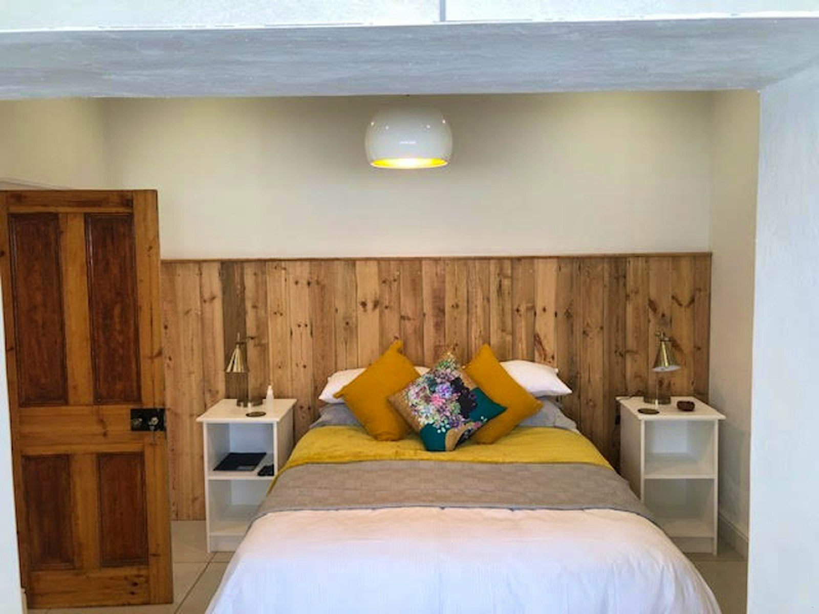 Bedroom with a timber headboard and wooden door